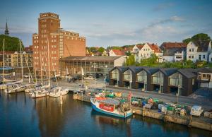 a boat docked at a marina in a city at Netzschuppen 4 in Kappeln