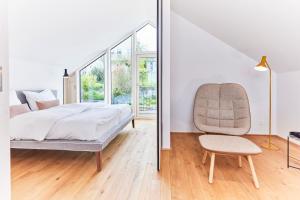 a bedroom with a bed and a chair at Netzschuppen 2 in Kappeln