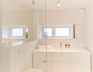 a white bathroom with a sink and a mirror at Netzschuppen 2 in Kappeln