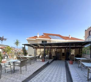 a patio with tables and chairs on a building at Residencial do Vale in Funchal