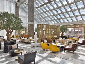a lobby with couches and chairs and a large glass ceiling at Sofitel Riyadh Hotel & Convention Centre in Riyadh