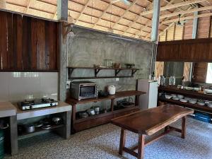 a kitchen with a table and a refrigerator at บ้านวารีชีวา WareeCheewa in Ban Muai