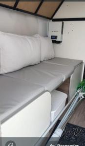 a white bed in the back of a small boat at Trailer cassa Rodante in Posadas