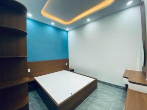 a bed in a room with a blue wall at Bhome in Vung Tau
