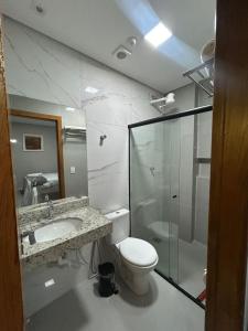 a bathroom with a toilet and a sink and a shower at Hotel Almeida in Montes Claros