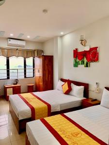 a hotel room with two beds with red and yellow at Huong Cang Sea View Hotel in Cat Ba