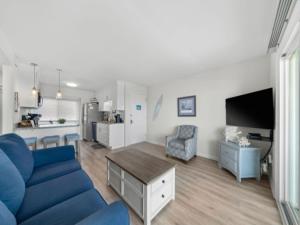 a living room with a blue couch and a kitchen at A Beach Dream condo in Carolina Beach +17 photos