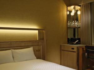 a hotel room with a bed and a sink at Candeo Hotels Chino in Chino +18 photos