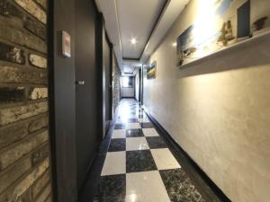 a hallway with a black and white checkered floor at Mora Stay in Busan
