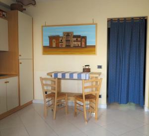 a table and chairs in a kitchen with a painting at Villa Anna "Davvero sulla Spiaggia" in Vasto