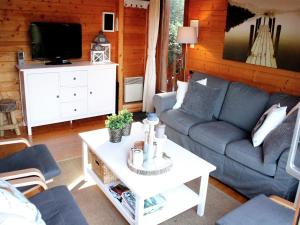a living room with a couch and a tv at Poolside Bliss Near Lake in Beaulieu