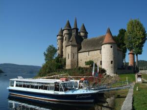 a boat in the water in front of a castle at Poolside Bliss Near Lake in Beaulieu