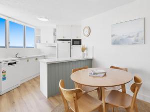 a kitchen and dining room with a table and chairs at Mandolin Beachfront Resort in Alexandra Headland