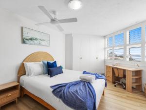 a bedroom with a bed and a desk and windows at Mandolin Beachfront Resort in Alexandra Headland +213 photos