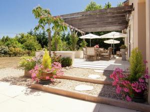 a patio with a table and chairs and flowers at Rouzède Villa with Pool in La Séguinie