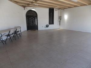 a large room with chairs and a table and a door at La Sierra Departamento 1 in Ciudad Juarez