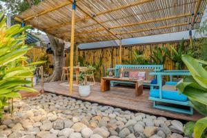 a patio with a wooden deck with a bench and a table at Casa Kapuas in Gili Trawangan