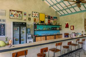 a bar in a restaurant with chairs and a counter at Casa Kapuas in Gili Trawangan