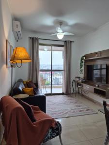 a living room with a tv and a couch and a television at Olímpia Super Stay in Olímpia