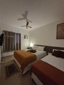 a bedroom with two beds and a ceiling fan at Olímpia Super Stay in Olímpia +19 photos