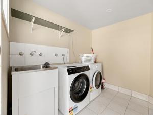 a laundry room with a washing machine and a sink at North Ipswich 1BR Pine Studio in Ipswich