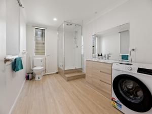 a white bathroom with a washing machine in it at North Ipswich 1BR Pine Studio in Ipswich