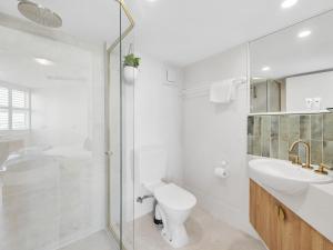 a bathroom with a toilet and a sink and a shower at Mandolin Beachfront Resort in Alexandra Headland