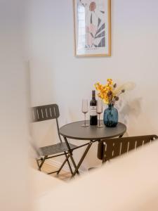 a table and two chairs and a table with wine glasses and flowers at North Ipswich 1BR Pine Studio in Ipswich +1 photo