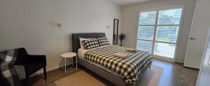 a bedroom with a bed and a chair and a window at Marittimo in Point Lonsdale