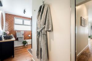 a bathroom with a robe hanging on a wall at Puna BnB in Matamata