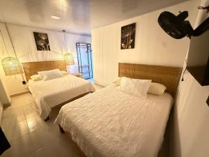 a hotel room with two beds in a room at toba Hotel- 5 min Centro Ibague in Ibagué