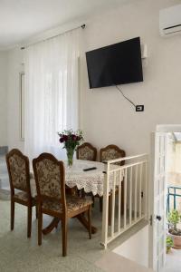 a dining room with a table and chairs and a tv at Centro Storico Di Tea in Turi