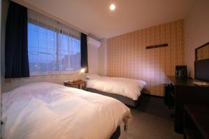 a hotel room with two beds and a window at Personal Hotel You in Takeo