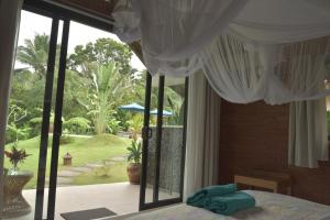 a bedroom with a bed with a view of a garden at Graha Ayoe Resort in Sidemen +43 photos