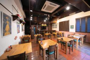 an empty restaurant with wooden tables and chairs at Personal Hotel You in Takeo +26 photos
