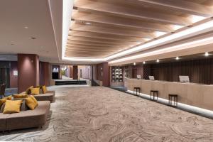 a lobby of a hotel with couches and a bar at KAMENOI HOTEL Kusatsu Resort in Kusatsu