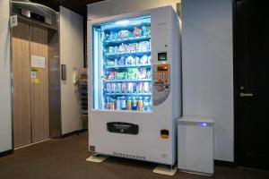a refrigerator filled with drinks in a hallway at Personal Hotel You in Takeo