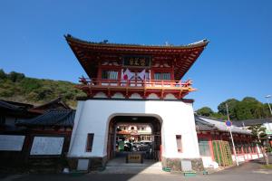 a red and white building with an archway at Personal Hotel You in Takeo