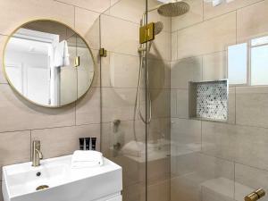 a bathroom with a shower and a sink and a mirror at The Winegrower's Cottage in Broke +8 photos