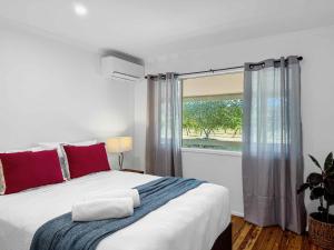 a bedroom with a large bed and a window at The Winegrower's Cottage in Broke