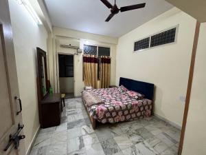 a bedroom with a bed and a ceiling fan at Aijaz Arcade in Hyderabad