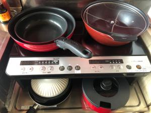 a stove with a pot and a pan on it at サウスウインズ in Kagebai