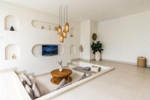 a living room with a couch and a table at Nirvana Canggu 2BR Near Berawa in Mantaak