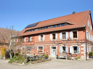 un gran edificio de ladrillo con un banco delante en Ferienwohnungen Schuh, en Ipsheim