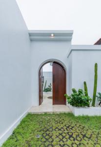 a door in a white house with a yard at Nirvana Canggu 2BR Near Berawa in Mantaak