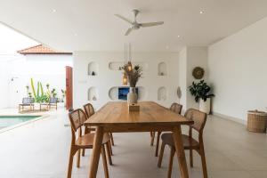 a dining room with a wooden table and chairs at Nirvana Canggu 2BR Near Berawa in Mantaak