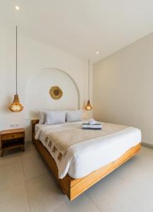 a bedroom with a large white bed with two lights at Nirvana Canggu 2BR Near Berawa in Mantaak +43 photos