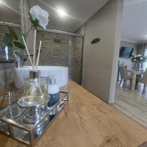 a living room with a glass table with a bath tub at Bella Rosa in Potchefstroom