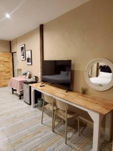 a room with a table with a tv and a mirror at กมุทมาศ สวรรคโลก in Ban Pa Muang (1)