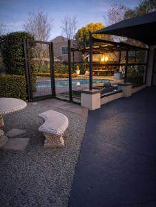 a bench sitting next to a gate with a pool at Bella Rosa in Potchefstroom